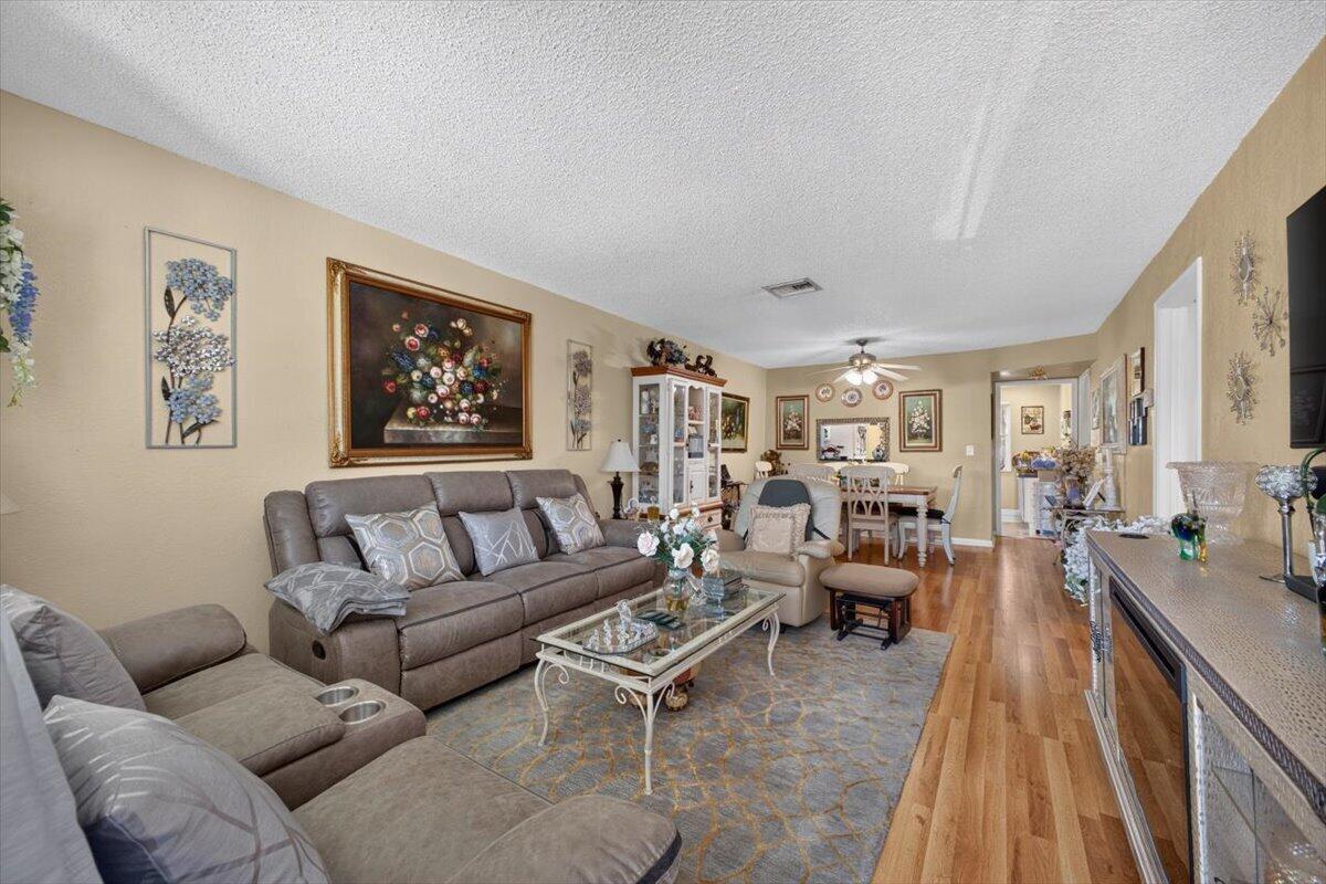 A living room features a brown sofa, a glass coffee table, and hardwood flooring — 55 SE 14th Street # 2060, Boca Raton FL 33432, BOCA RATON, FL