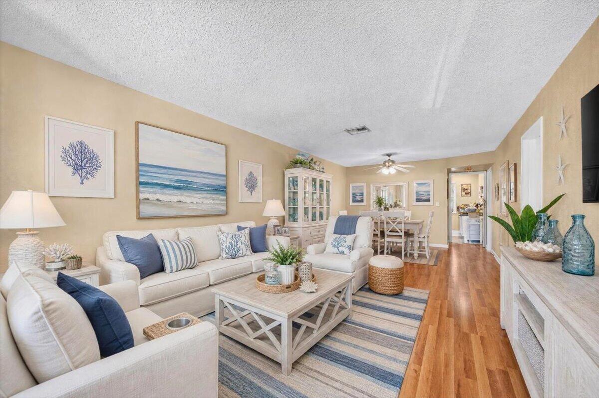 A coastal-style living room features light wood floors, a white sofa, and a coffee table — 55 SE 14th Street # 2060, Boca Raton FL 33432, BOCA RATON, FL