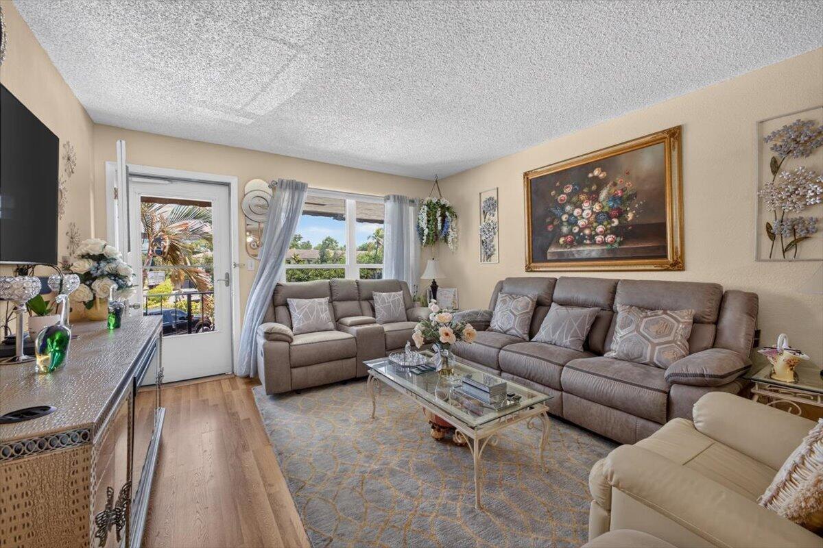 A living room features a brown sofa, a glass coffee table, and a patterned rug — 55 SE 14th Street # 2060, Boca Raton FL 33432, BOCA RATON, FL