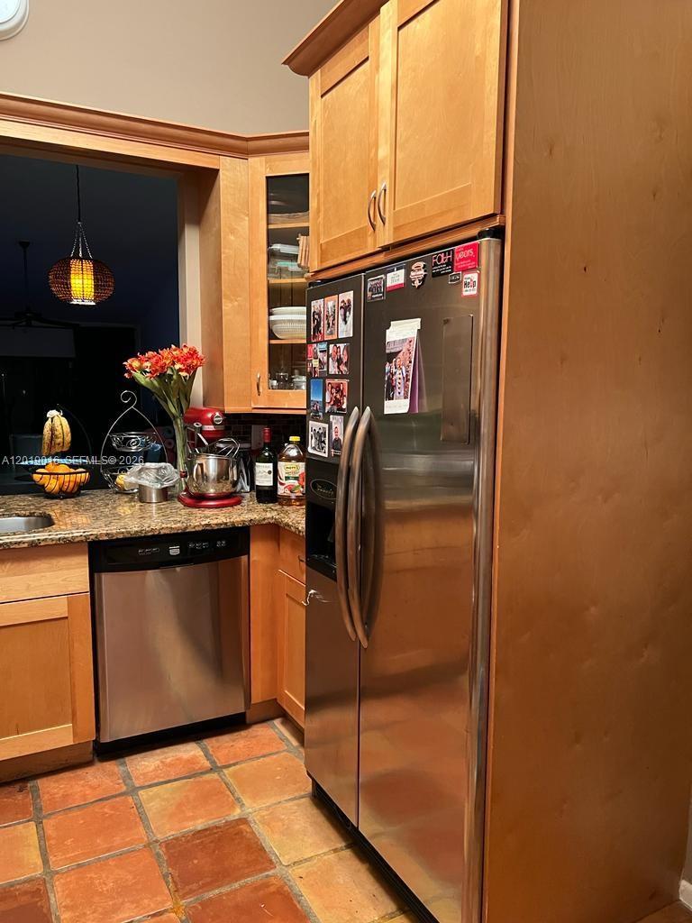 A kitchen features light wood cabinets, stainless steel appliances, and terracotta tile flooring — 509 NE 199th Ln # 3A, Miami FL 33179, MIAMI, FL