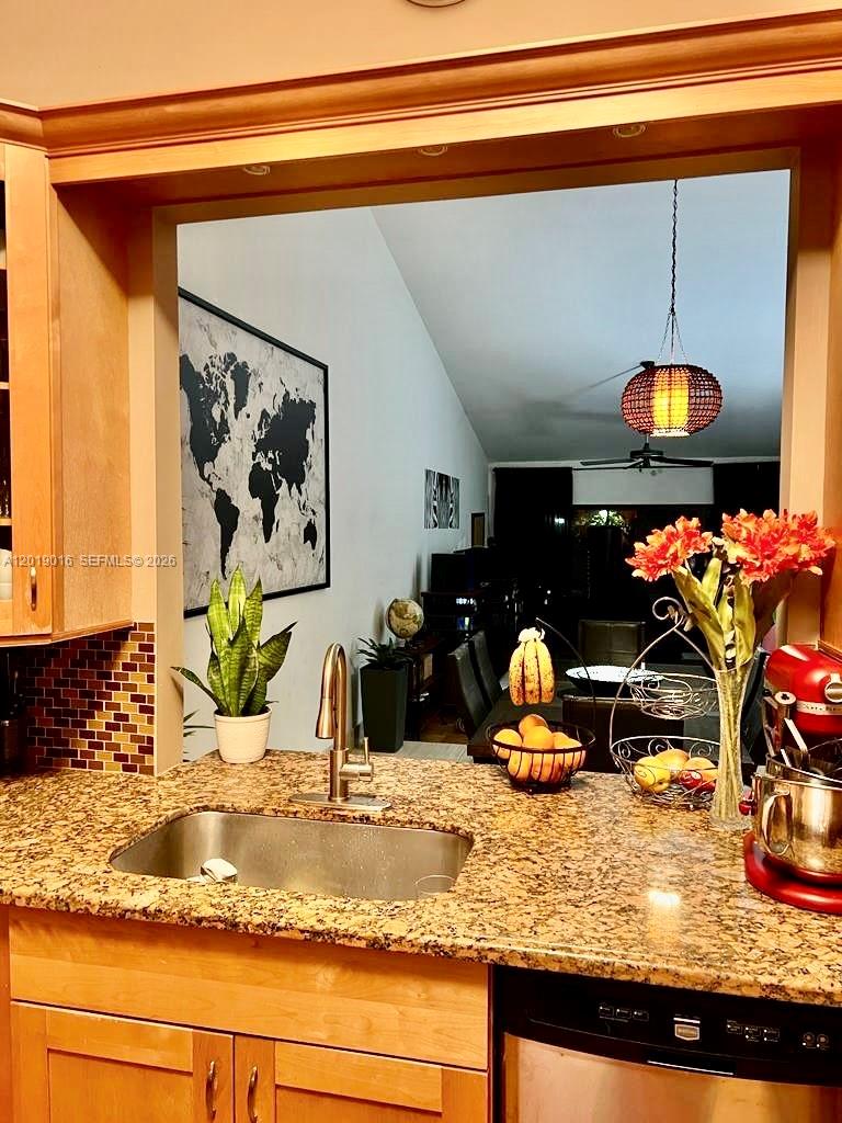 A kitchen sink and granite countertop overlook a dining area with a world map — 509 NE 199th Ln # 3A, Miami FL 33179, MIAMI, FL