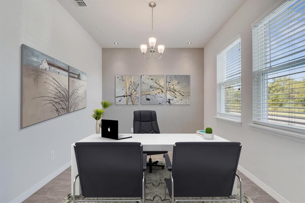 A home office features a white desk, three black chairs, and abstract wall art — 8048 SCAGEL STREET, ORLANDO, FL