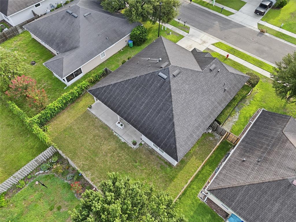 An aerial view shows the dark shingled roof of a house with a backyard patio — 16634 NW 193RD TERRACE, HIGH SPRINGS, FL