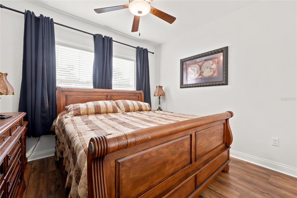 A bedroom features a wooden sleigh bed, dark curtains, and a ceiling fan — 16634 NW 193RD TERRACE, HIGH SPRINGS, FL