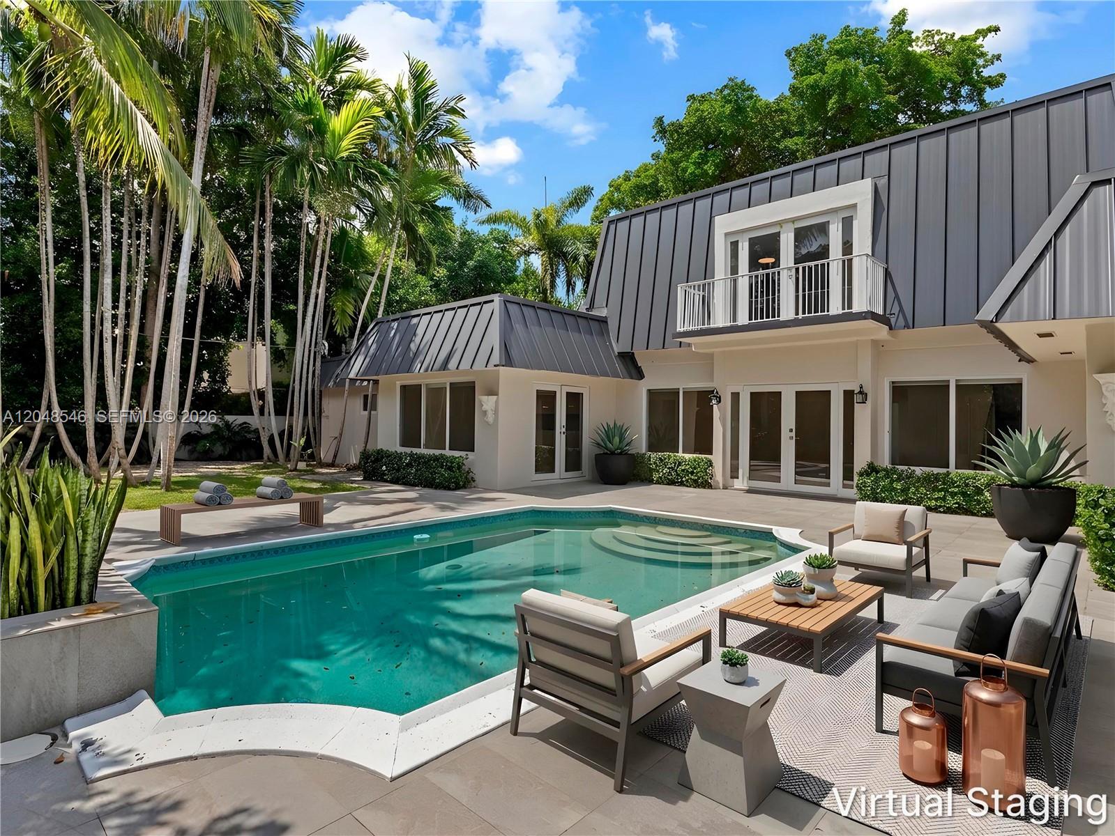A backyard features a swimming pool, a patio with outdoor furniture, and a two-story house — KEY BISCAYNE, FL