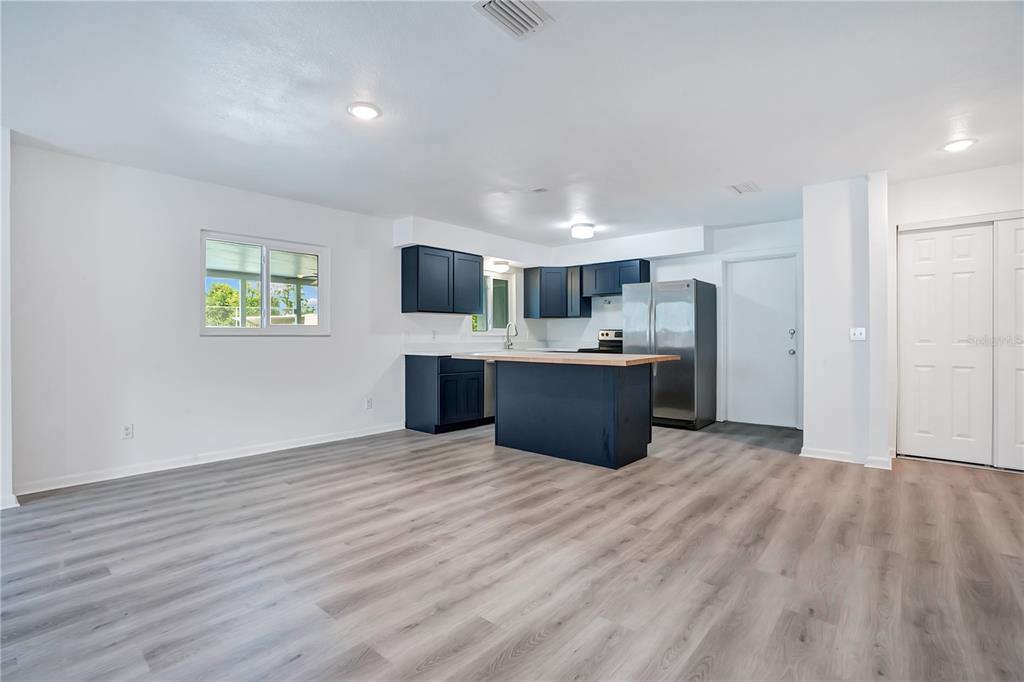 A kitchen with dark blue cabinets, a wooden island, and light wood-look flooring — 205 FERN ROAD, WINTER HAVEN, FL