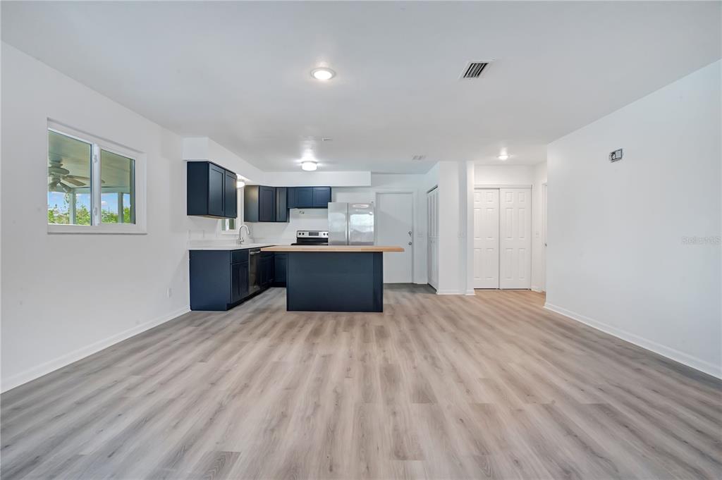A kitchen with dark blue cabinets, a wooden island, and light wood-look flooring — 205 FERN ROAD, WINTER HAVEN, FL