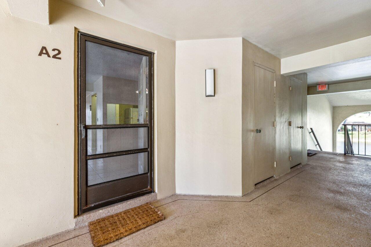 An apartment entrance with a screen door labeled A2, a doormat, and a hallway — 618 Sea Pine Way # A2, FL 33415, FL