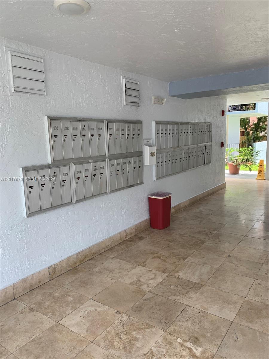 A hallway features rows of metal mailboxes mounted on a white wall above tiled floors — 1221 SW 122nd Ave # 207, Miami FL 33184, MIAMI, FL