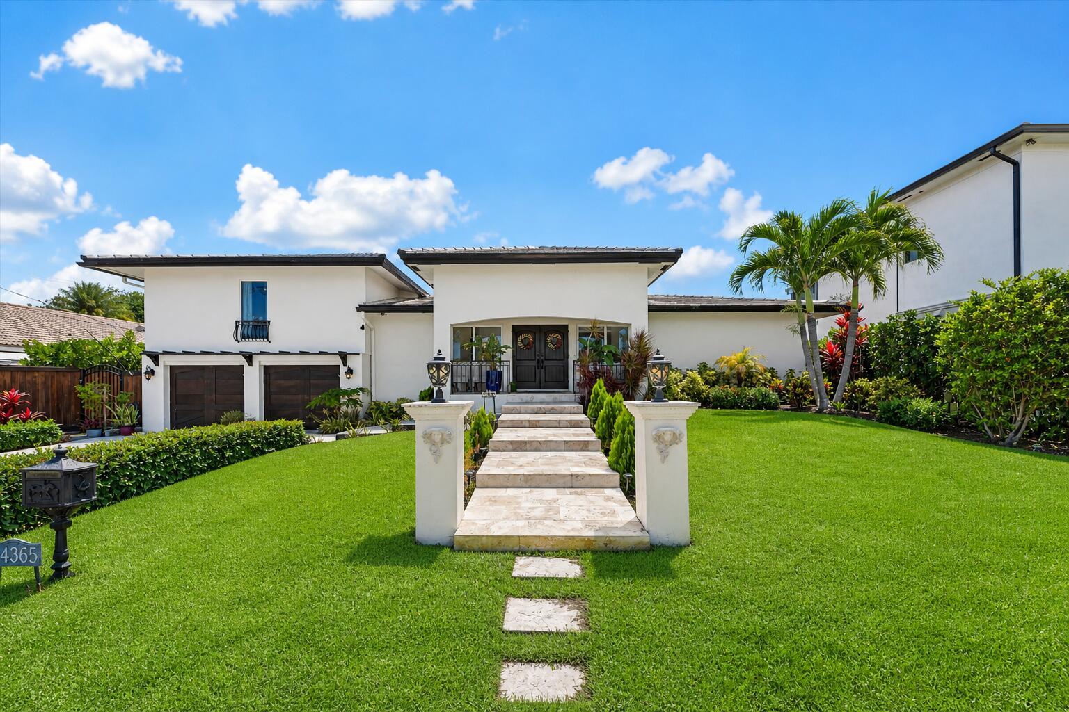 A white modern house with a stone walkway, manicured lawn, and two-car garage — 2948 NE 35th Court, Lighthouse Point FL 33064, LIGHTHOUSE POINT, FL