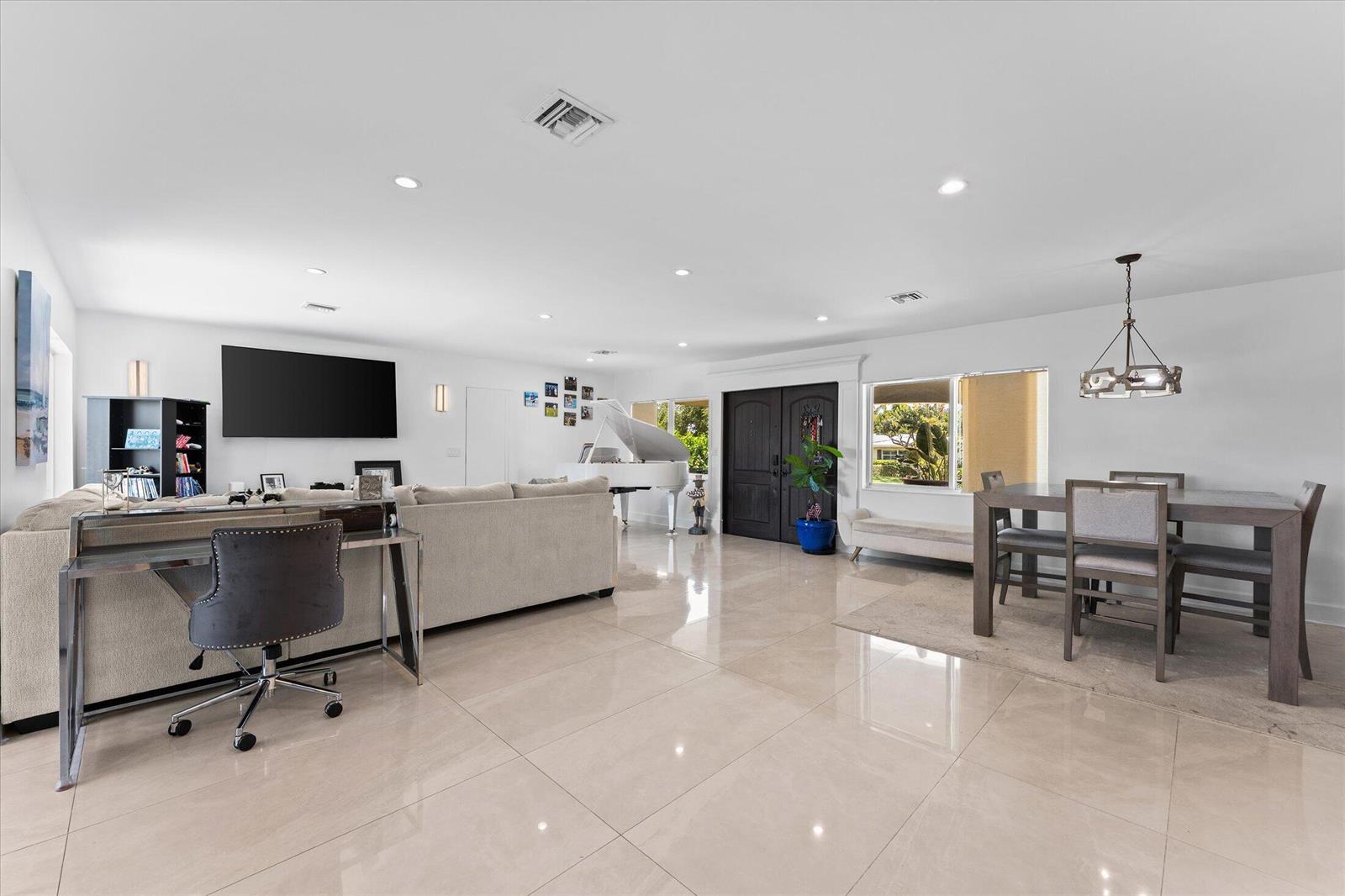 An open-concept living and dining area features white walls, tile flooring, and a grand piano — 2948 NE 35th Court, Lighthouse Point FL 33064, LIGHTHOUSE POINT, FL