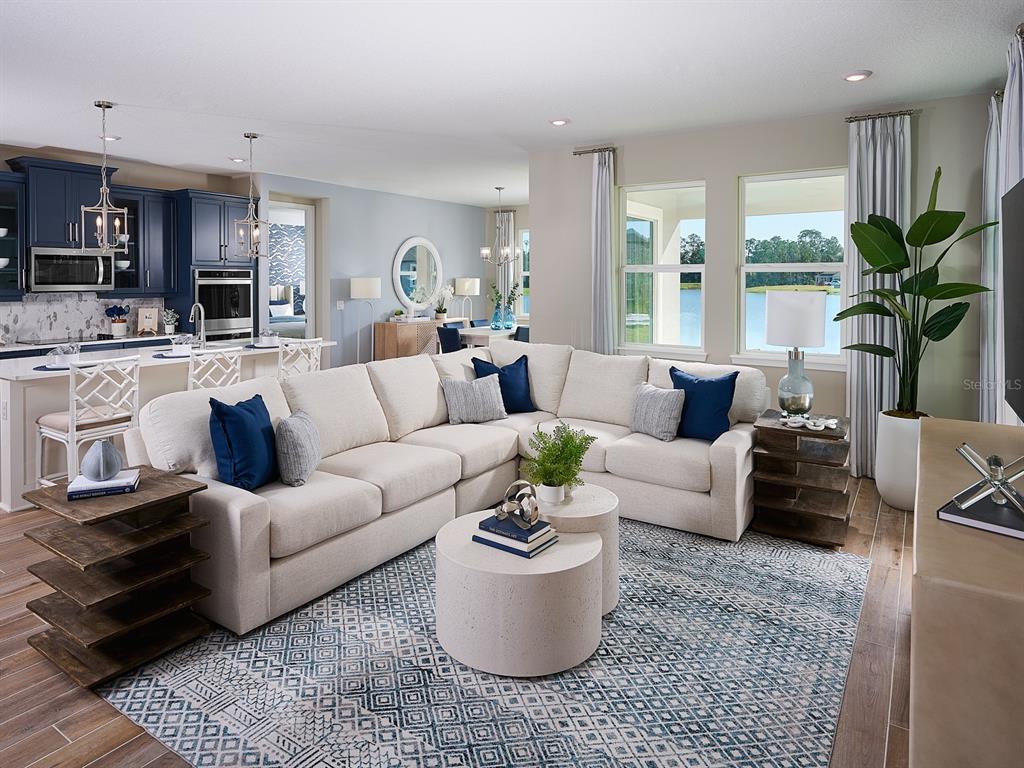 A living room with a large sectional sofa, nested coffee tables, and an open kitchen — 384 BIRKDALE DRIVE, DAYTONA BEACH, FL