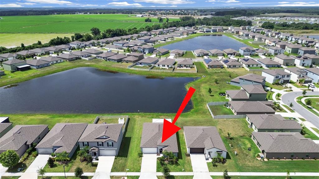 An aerial view shows a single-story suburban house with a red arrow pointing to it — 5413 BLUE AZURE DRIVE, WIMAUMA, FL