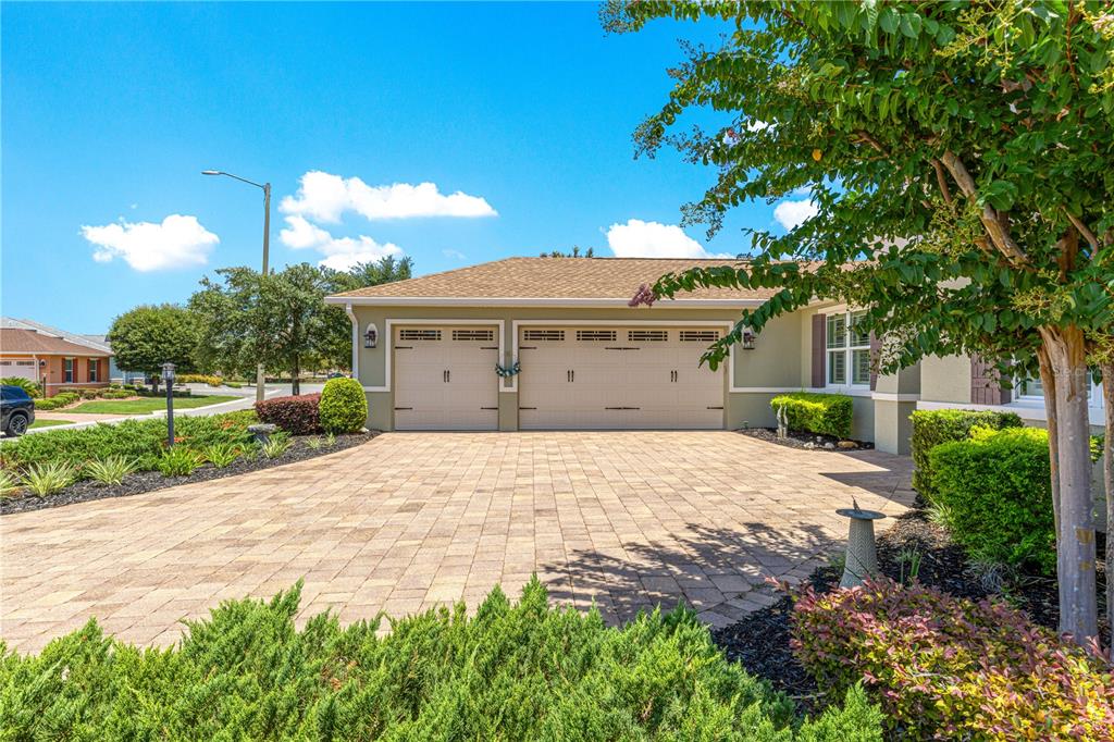 A paved driveway leads to a two-car garage in front of a single-story suburban home — 8689 SW 93RD CIRCLE, OCALA, FL