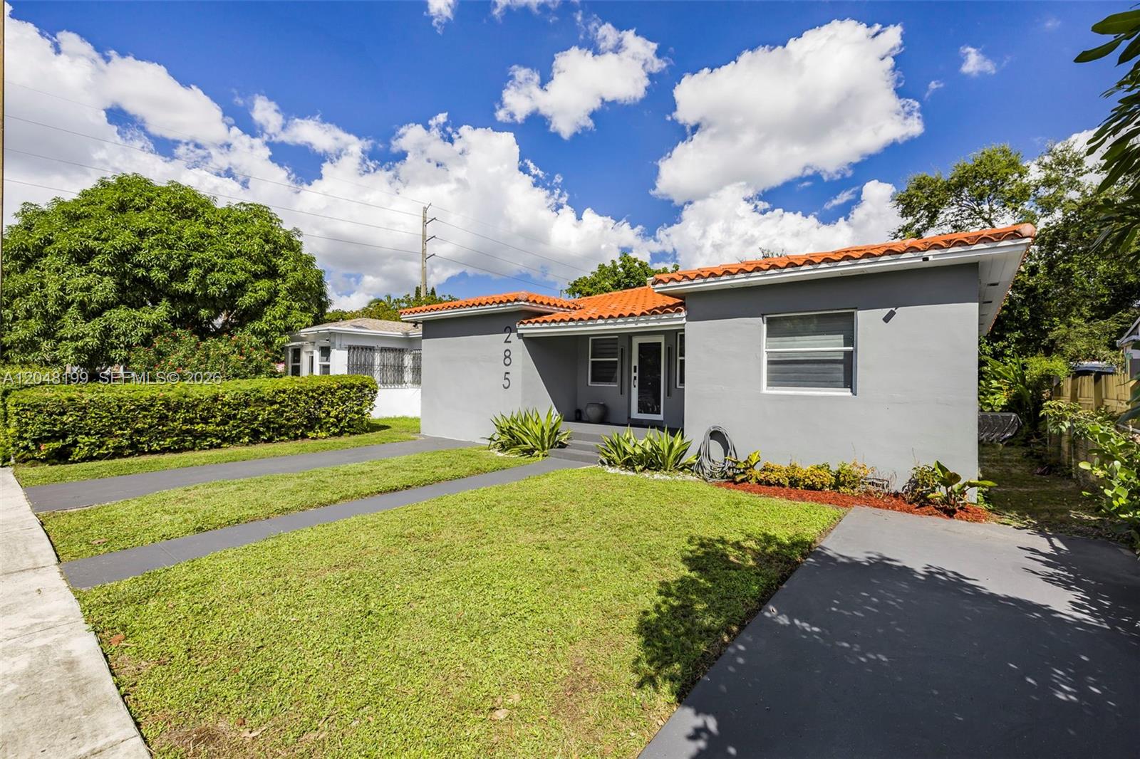 A single-story gray house with a red tile roof and a front lawn — 285 NW 45th St, Miami FL 33127, MIAMI, FL