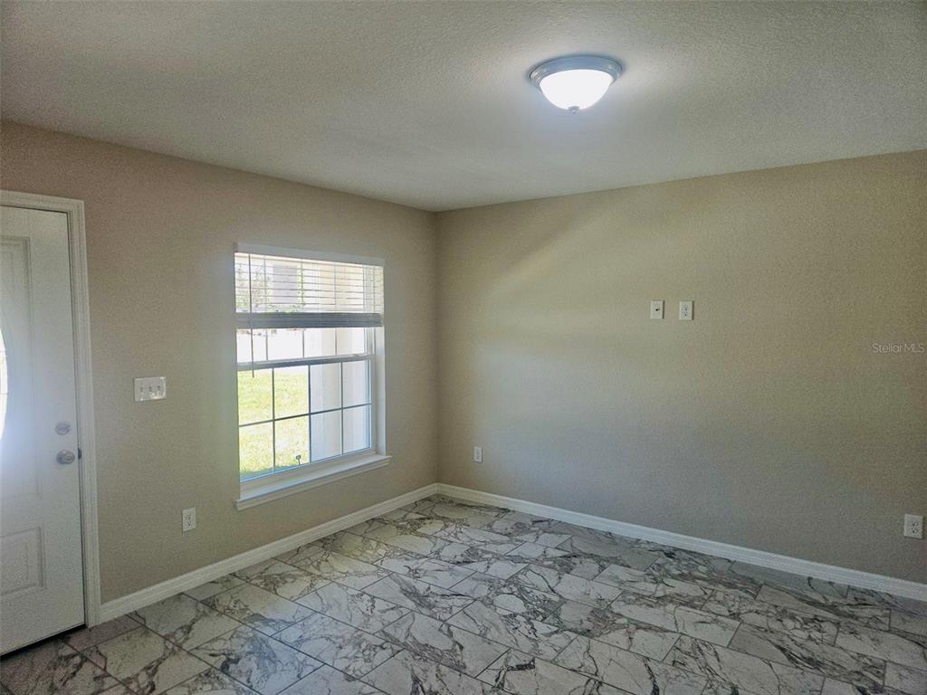 A room with beige walls, a window with blinds, and a marble-patterned tile floor — 328 MOUNTAIN DRIVE, BABSON PARK, FL