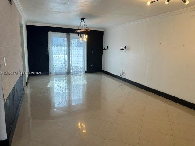 An empty room features white walls, a dark accent wall, tile flooring, and light fixtures — 6175 W 20th Ave # 309, Hialeah FL 33012, HIALEAH, FL