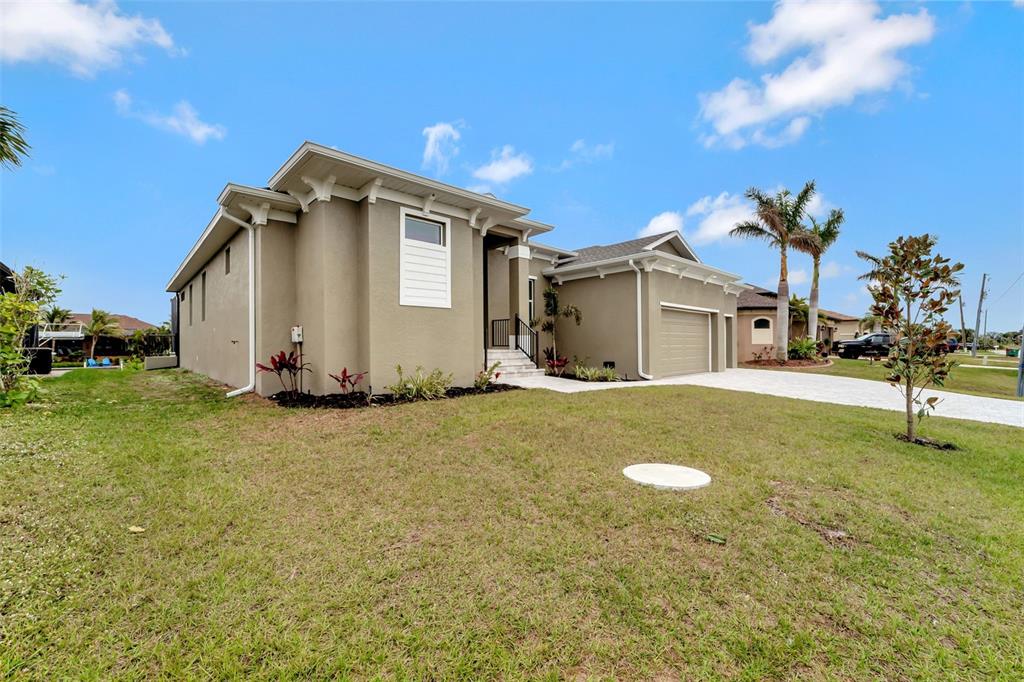 A single-story beige house with a two-car garage and a paved driveway — 10508 MCALESTER CIRCLE, PORT CHARLOTTE, FL