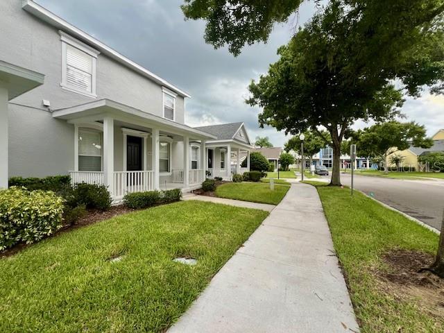 A sidewalk leads past the front porches of two-story gray houses with white trim — 14252 CONFETTI DRIVE, WINDERMERE, FL