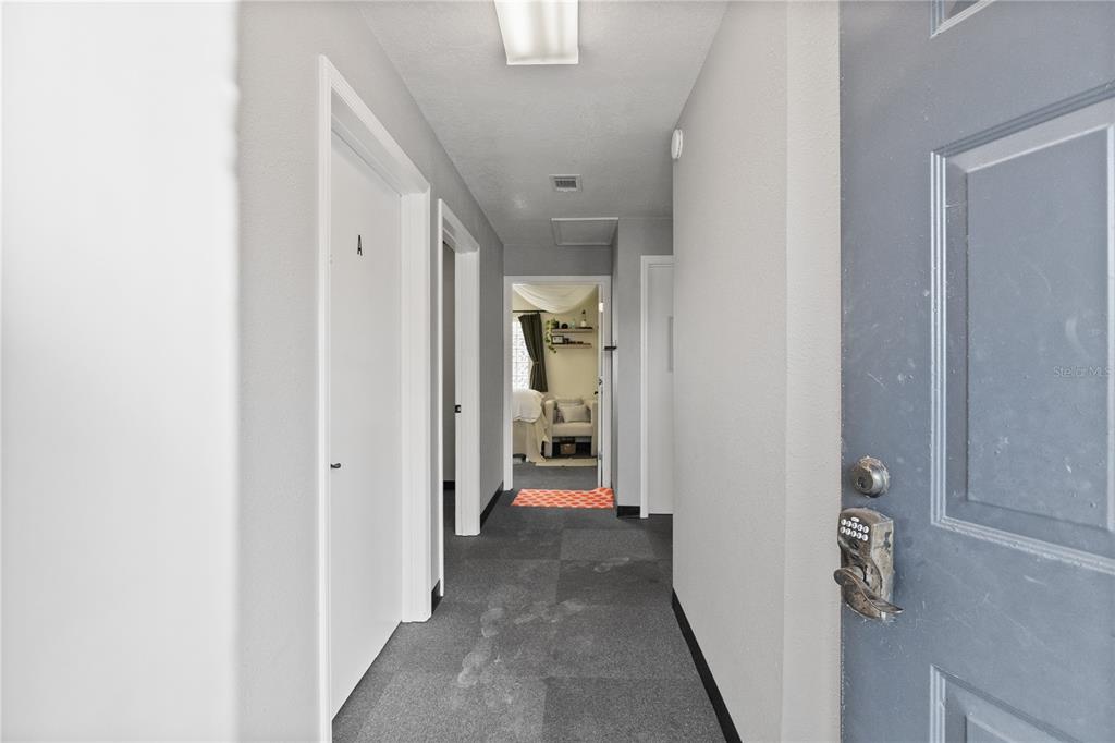 A gray hallway features a door with a keypad lock and leads to another room — 684 W MONTROSE STREET UNIT 690/E, CLERMONT, FL
