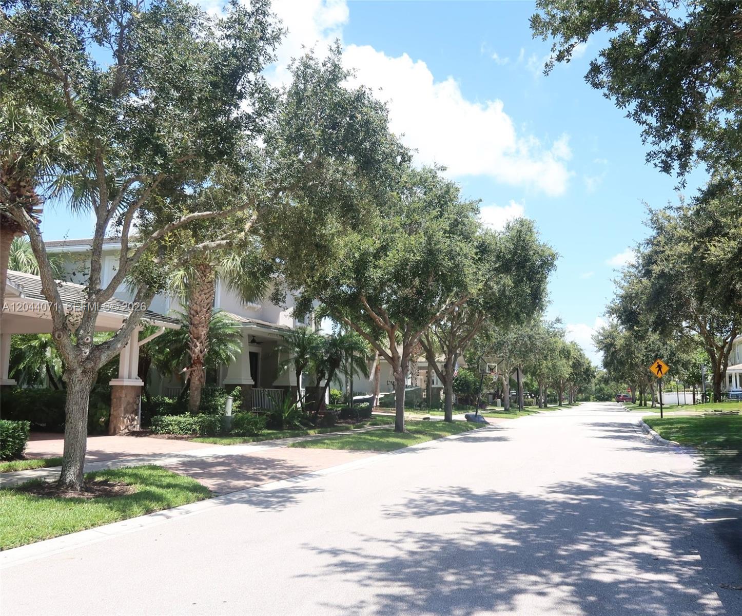 A quiet residential street lined with mature trees and houses on a sunny day — 2724 Wymberly Dr, Jupiter FL 33458, JUPITER, FL