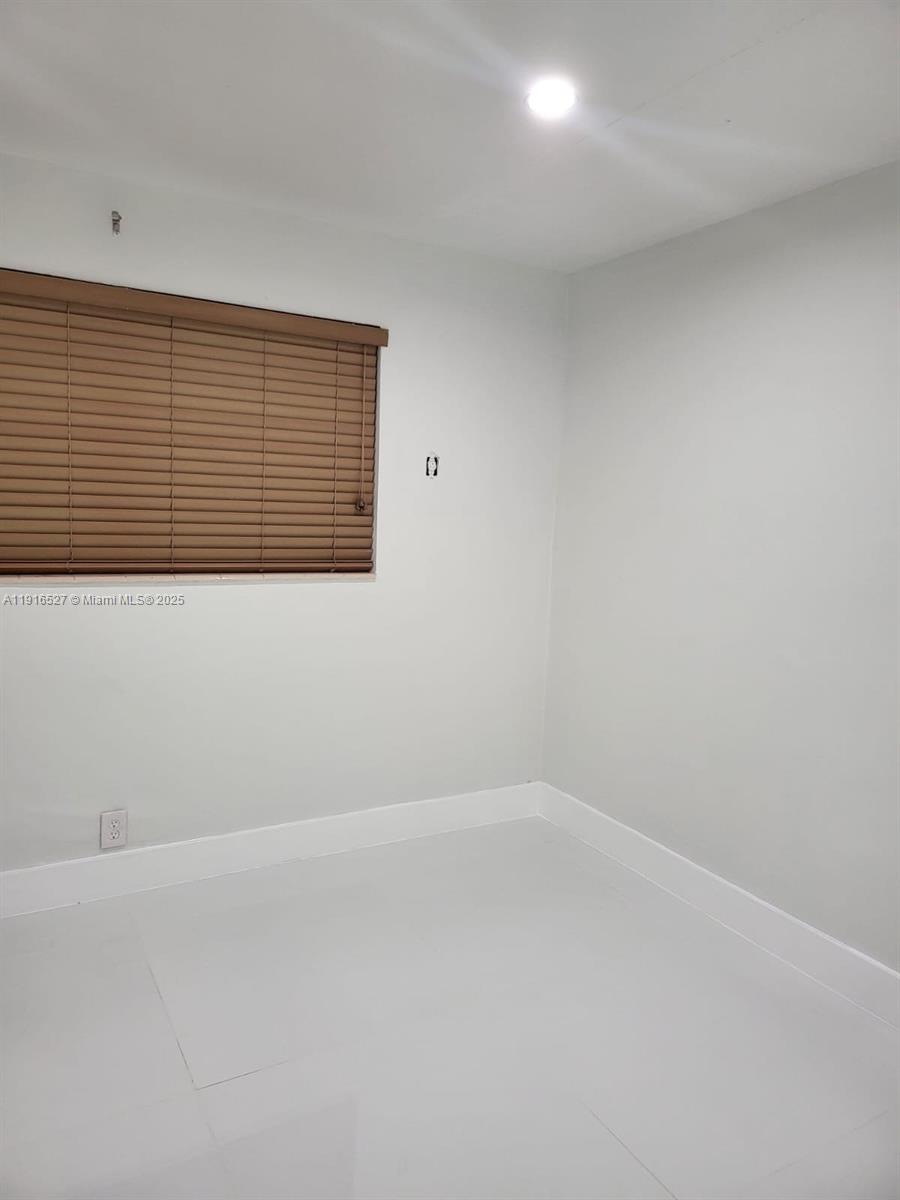 This room features light-colored walls, white baseboards, tiled flooring, and a window with blinds — 9375 SW 40th Ter # 203, Miami FL 33165, MIAMI, FL