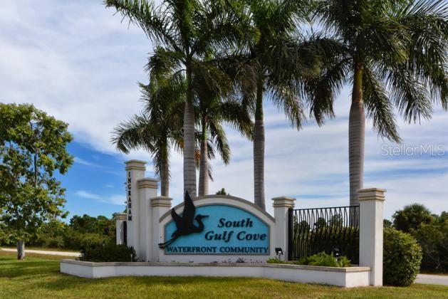 A sign for the South Gulf Cove waterfront community stands beneath tall palm trees — 16573 LIGGETT CIRCLE, PORT CHARLOTTE, FL