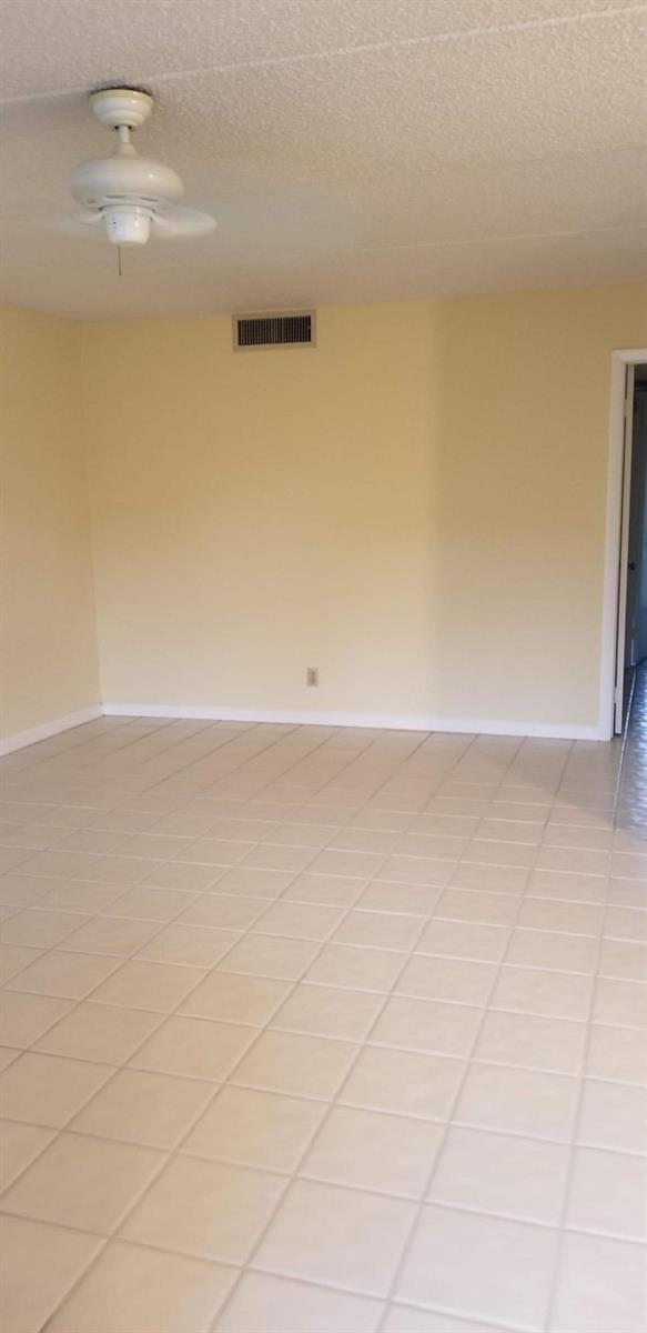 An empty room with light-colored tile flooring, beige walls, and a ceiling fan — 2000 Springdale Boulevard # 203, Palm Springs FL 33461, PALM SPRINGS, FL