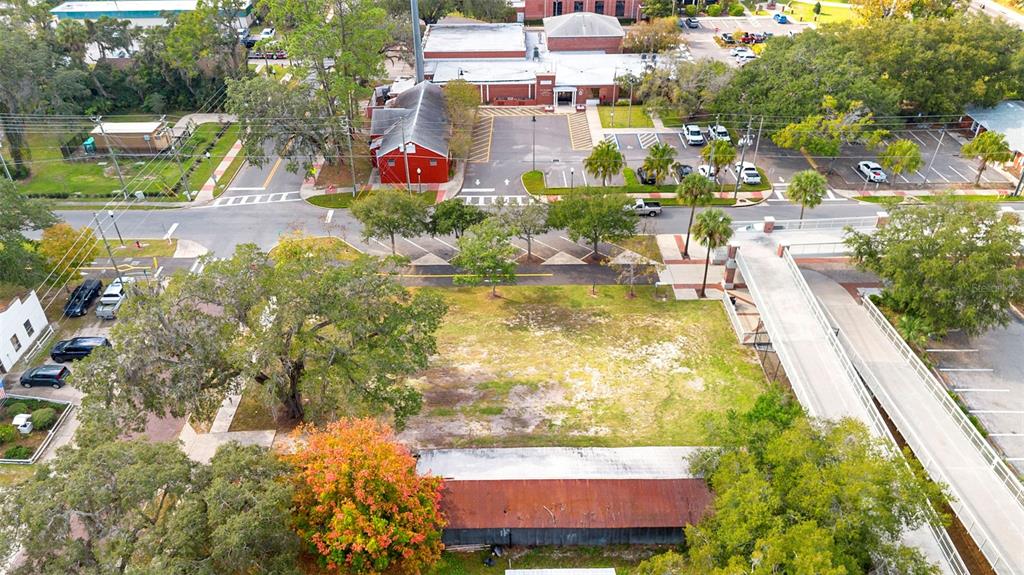 An aerial view shows a vacant lot with a rusted shed next to a parking area — 215 E 5TH STREET, APOPKA, FL