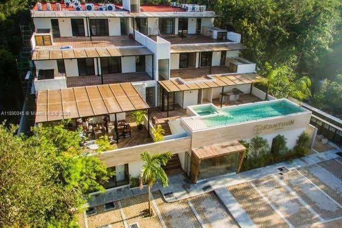 An aerial view of a multi-level modern building with terraces and a rooftop swimming pool — Kantuun Tulum Palenque, C. 3 Pte. con # A4, TX 77760, TX