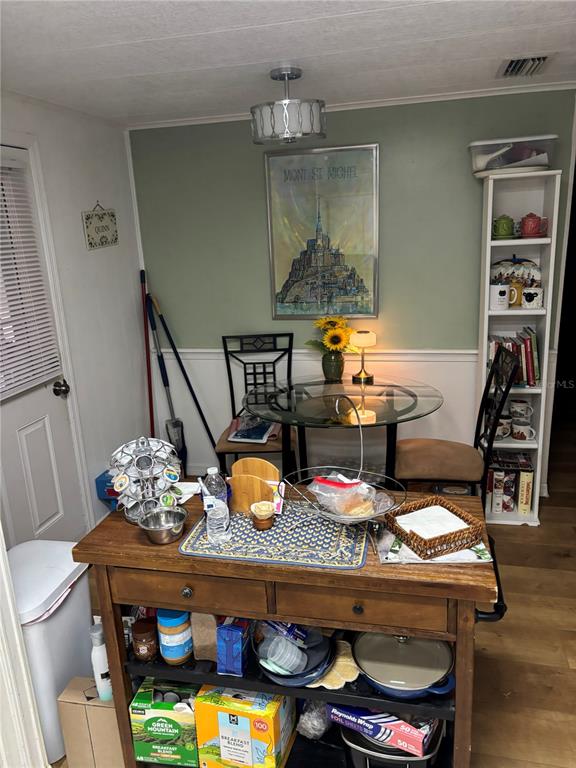 A kitchen features white cabinets, a central wooden island, and tile flooring — 3438 BANBERRY CIRCLE UNIT 1790, ZELLWOOD, FL