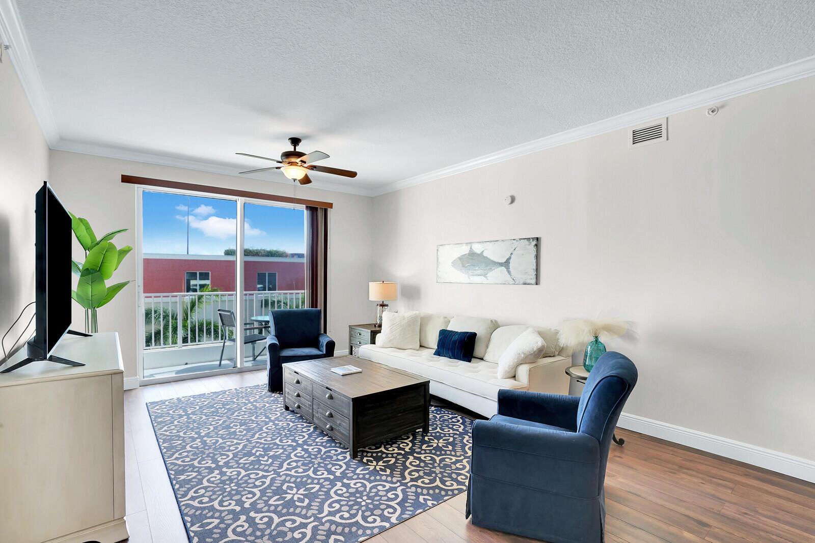 A living room features a white sofa, two blue armchairs, and a patterned area rug — 804 E Windward Way, Lantana FL 33462, LANTANA, FL