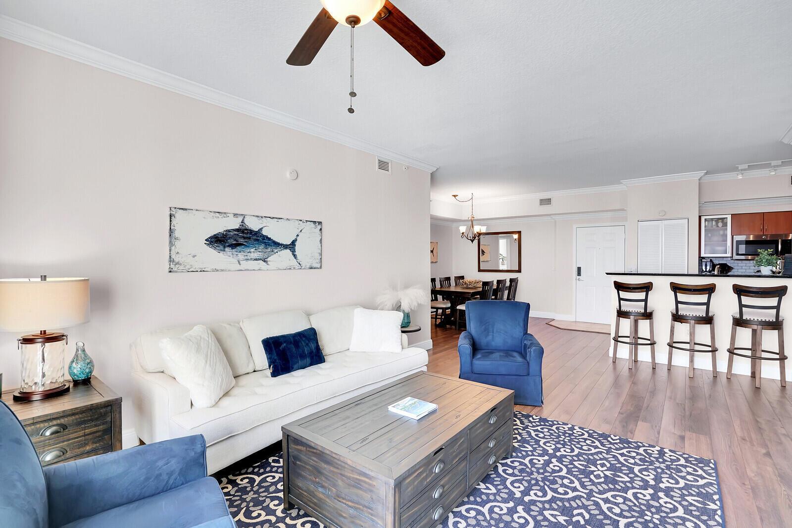A living room with a white sofa, blue armchairs, a wooden coffee table, and kitchen — 804 E Windward Way, Lantana FL 33462, LANTANA, FL