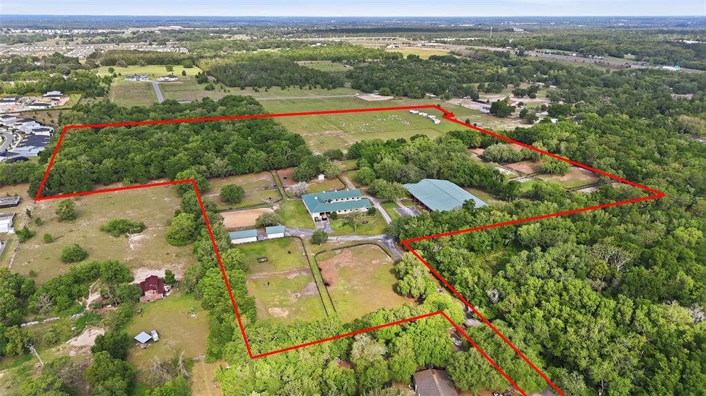 An aerial view shows a large rural property with multiple buildings, pastures, and wooded areas — 2020 HAAS ROAD, APOPKA, FL