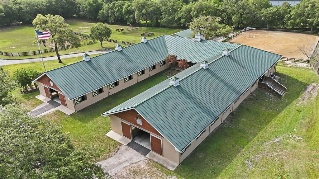 An aerial view shows a U-shaped horse stable with a green metal roof — 2020 HAAS ROAD, APOPKA, FL