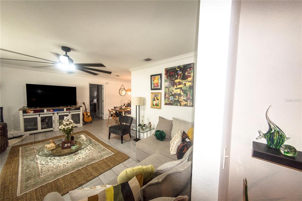 A living room features a sectional sofa, a glass coffee table, and a television console — 1721 FREEMAN DRIVE, KISSIMMEE, FL