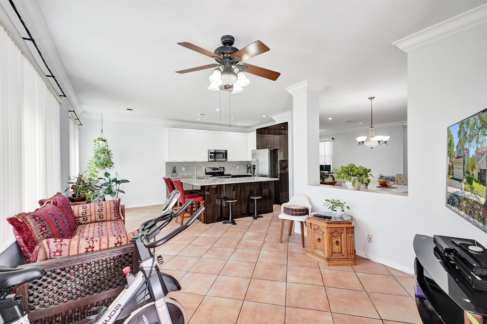 An open-concept living and dining area features tile flooring, a fireplace, and neutral walls — 873 Stanton Drive, Weston FL 33326, WESTON, FL