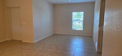An empty room with light-colored walls, tiled flooring, and a single window — 26172 EXPLORER ROAD UNIT 2, PUNTA GORDA, FL
