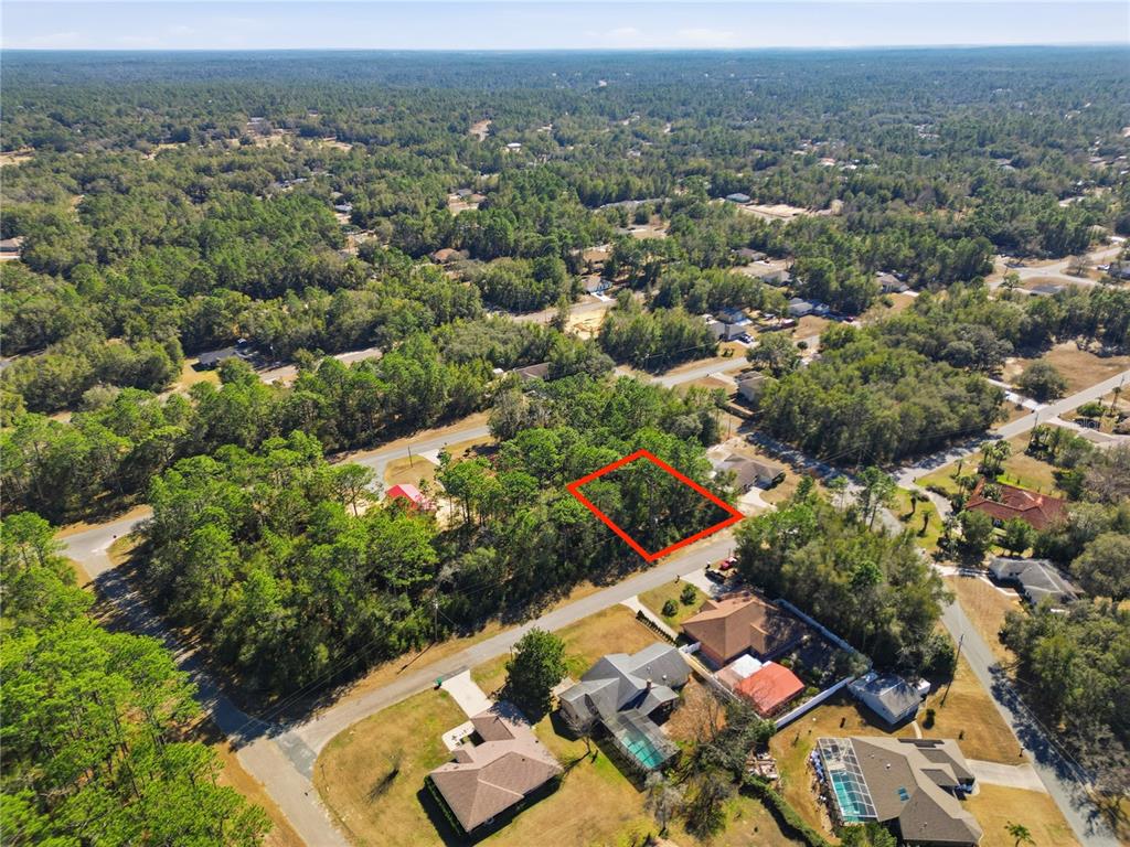 An aerial view shows a vacant, wooded residential lot outlined in red within a neighborhood — 2780 W ELGIN PLACE, CITRUS SPRINGS, FL