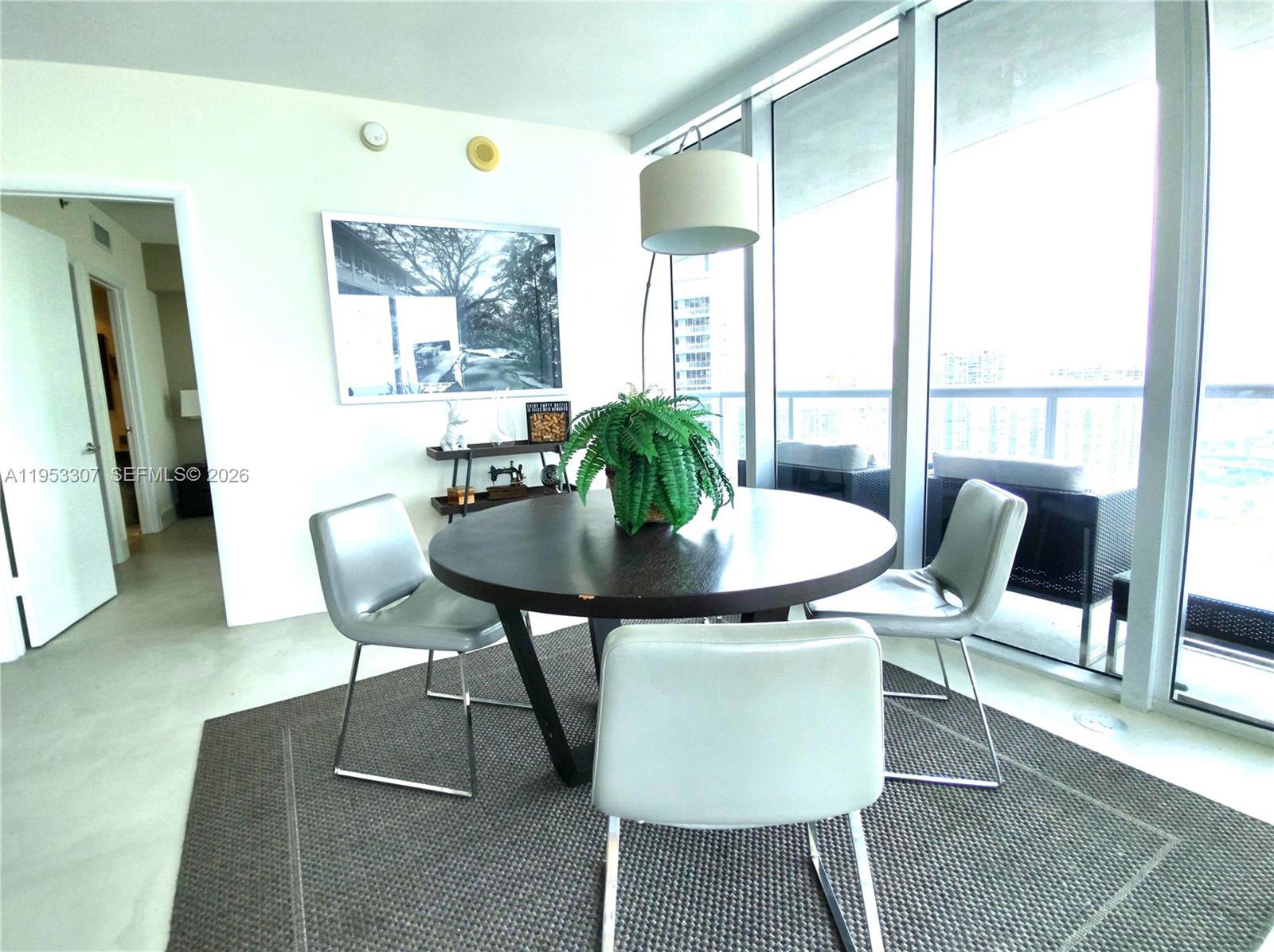 A dining area features a round table, four chairs, and floor-to-ceiling windows with balcony access — 465 Brickell Ave # 4402, Miami FL 33131, MIAMI, FL