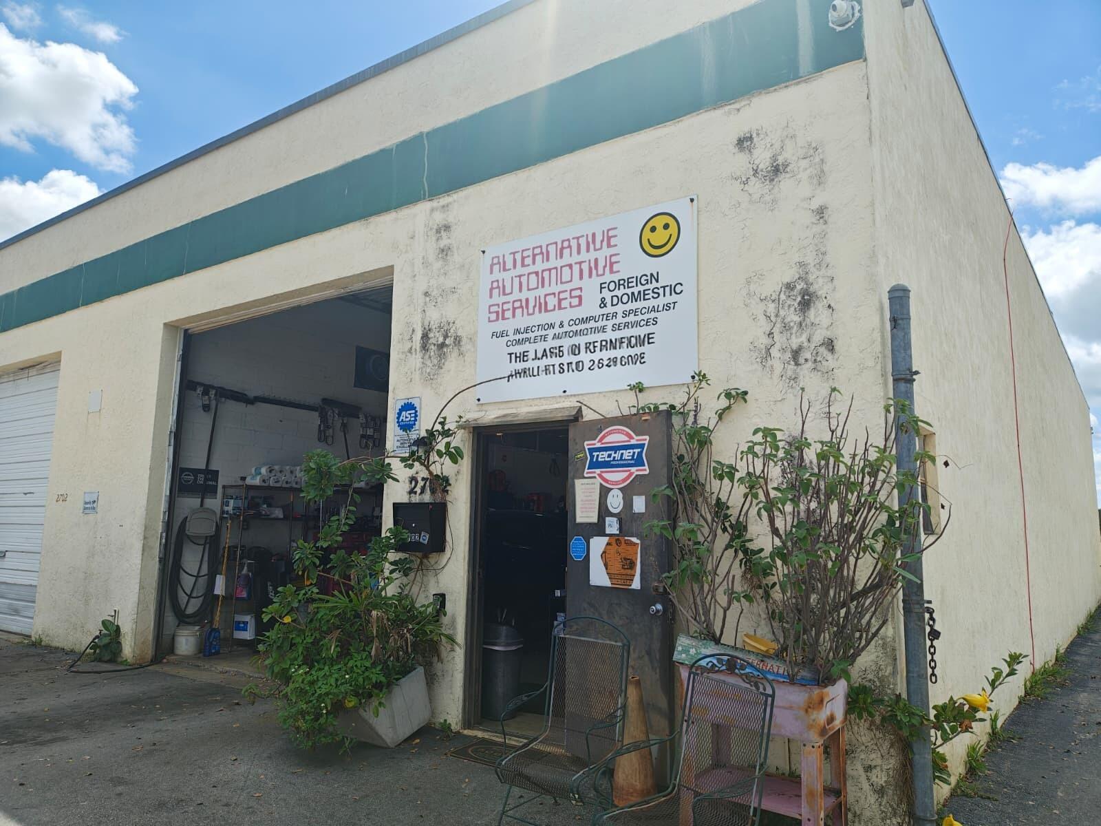 An exterior view of an automotive repair shop with a white sign and open bay door — 2702 Rockey Drive, West Palm Beach FL 33409, WEST PALM BEACH, FL