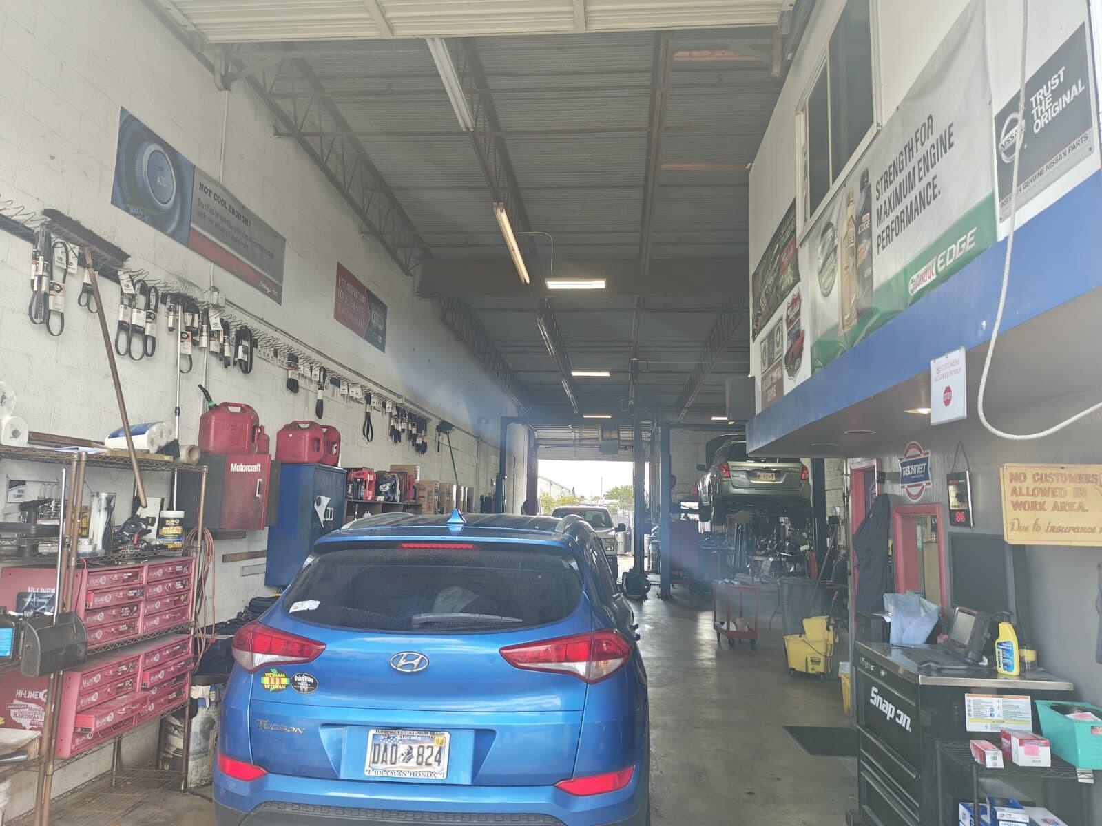 An auto repair shop features a blue Hyundai Tucson parked inside a service bay — 2702 Rockey Drive, West Palm Beach FL 33409, WEST PALM BEACH, FL