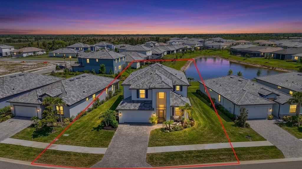An aerial view of a two-story suburban house with a red property line overlay — 10865 SUN DROP STREET, VENICE, FL