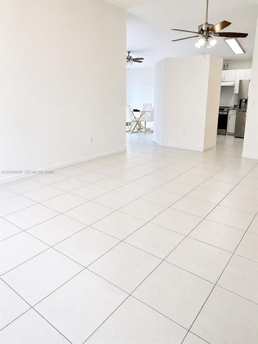 A tiled living area opens into a kitchen and a dining space with white walls — 17834 SW 144th Ct # 0, Miami FL 33177, MIAMI, FL
