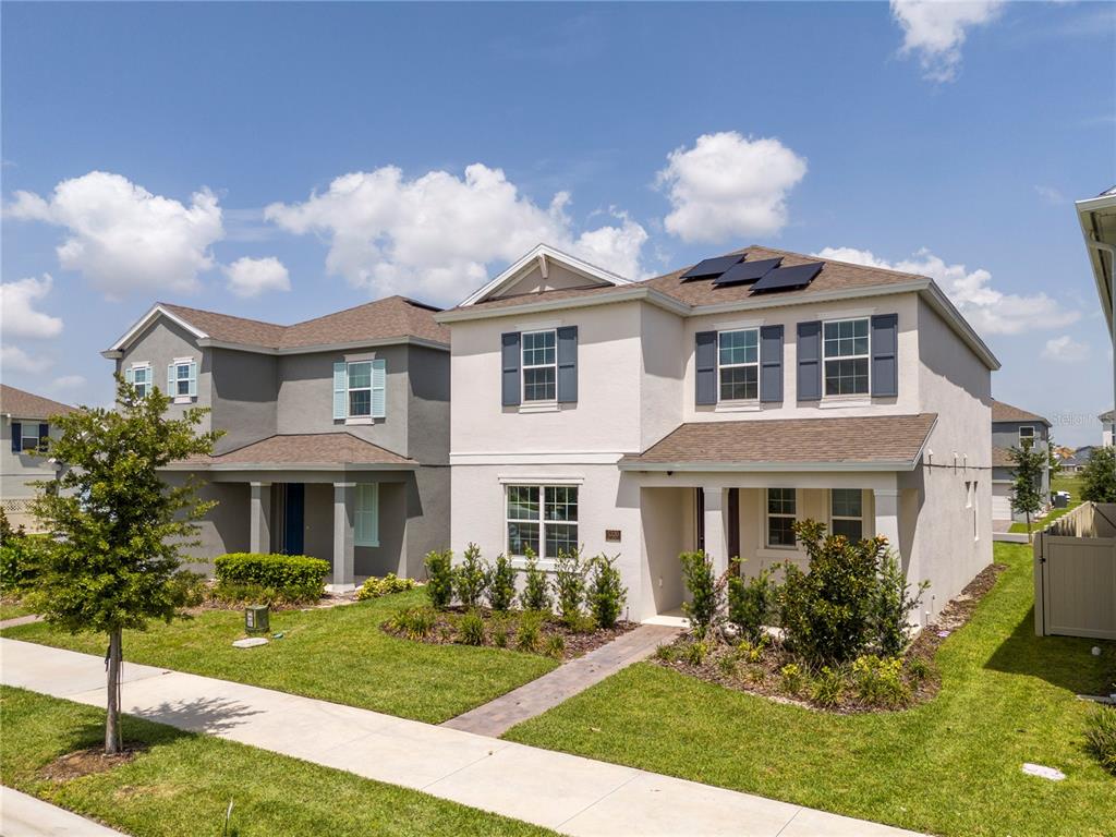 Two suburban two-story houses with light-colored stucco exteriors and front lawns under a blue sky — 5320 LAKE VIRGINIA STREET, WINTER GARDEN, FL