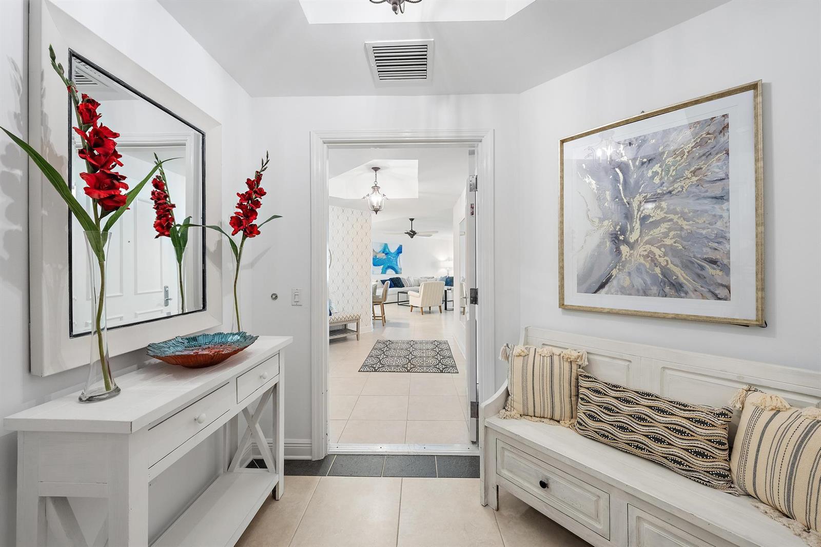 A bright entryway features a white console table, a bench, and a doorway to a living area — 400 S Us Hwy 1 # 303, Jupiter FL 33477, JUPITER, FL