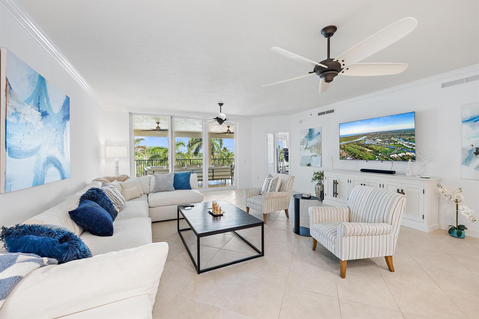 A bright living room features a white sectional, striped armchairs, a coffee table, and balcony views — 400 S Us Hwy 1 # 303, Jupiter FL 33477, JUPITER, FL