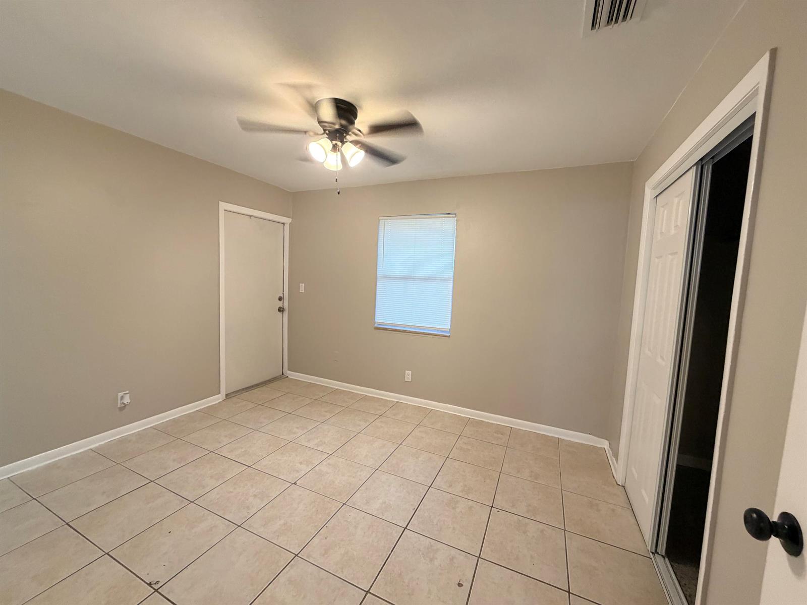 An empty bedroom features beige walls, a tile floor, a ceiling fan, and a closet — 612 4th Street, West Palm Beach FL 33401, WEST PALM BEACH, FL