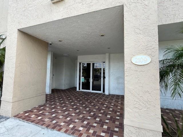 A covered entryway with a tiled floor leads to glass double doors at building 2109 — 2109 E PALM AVENUE, TAMPA, FL