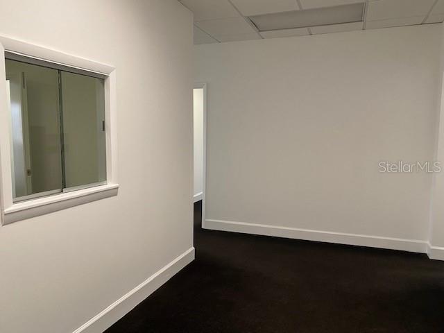 An empty office space features white walls, dark carpeting, and a sliding glass window — 2109 E PALM AVENUE, TAMPA, FL